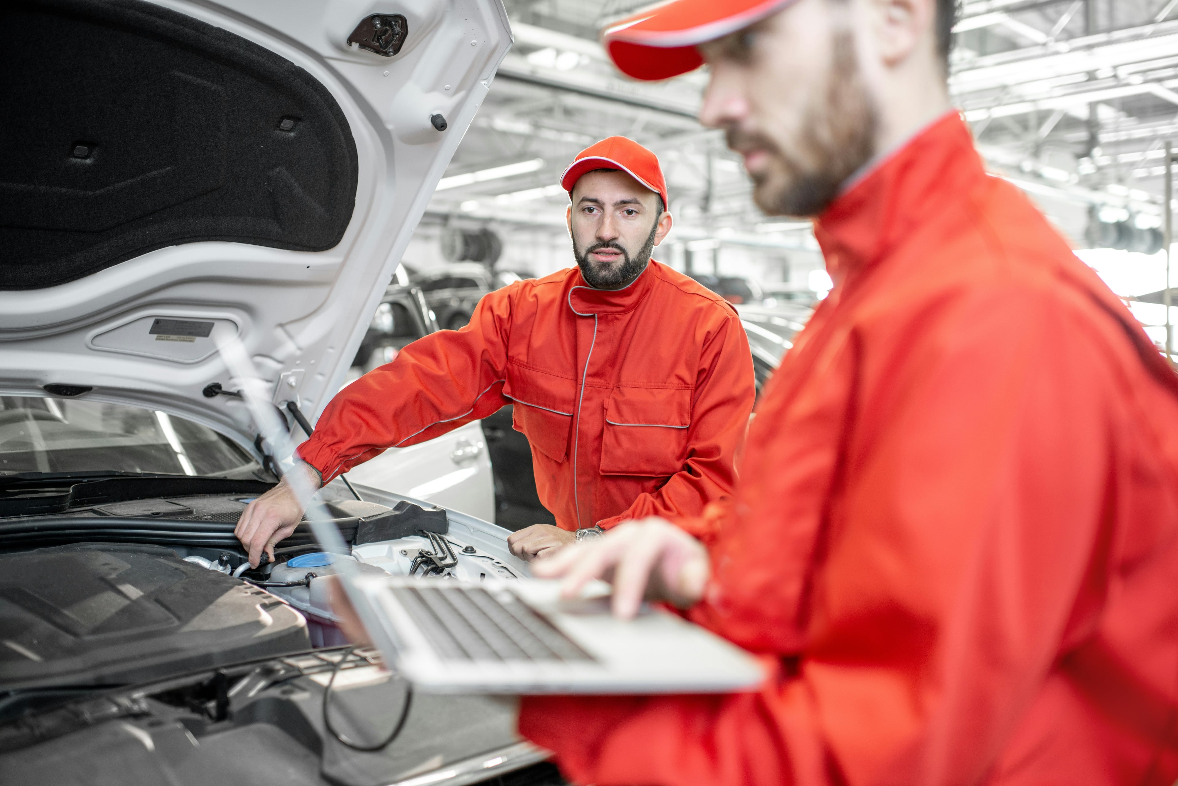 CarMate UAE automotive service center in Abu Dhabi showing professional mechanics and modern equipment